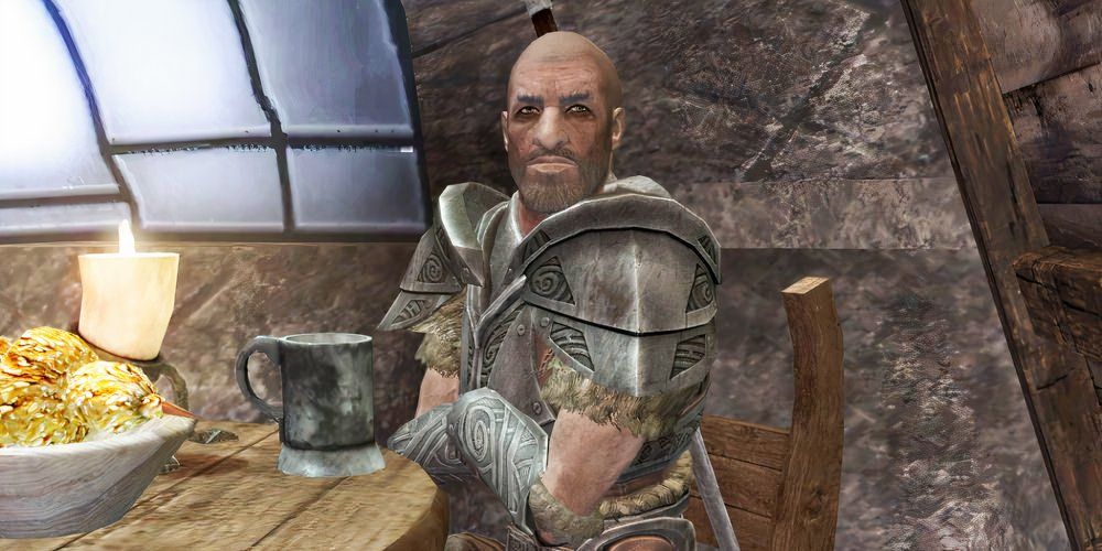 Stenvar from Elder Scrolls V: Skyrim is depicted sitting at his table in Candelhearth Hall in Windehlm.