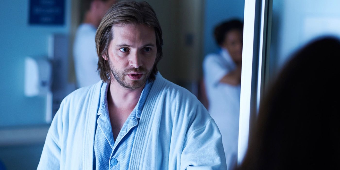 James Cole (ator Aaron Stanford) em uma camisa azul falando com uma figura em 12 Macacos