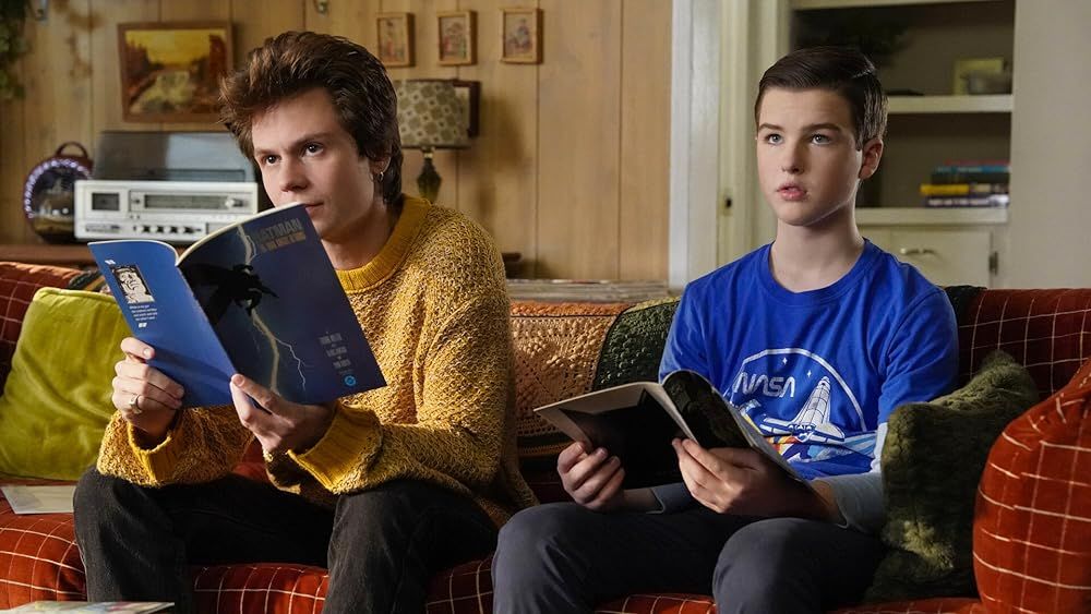 Connor and Sheldon look at books on the couch in Young Sheldon