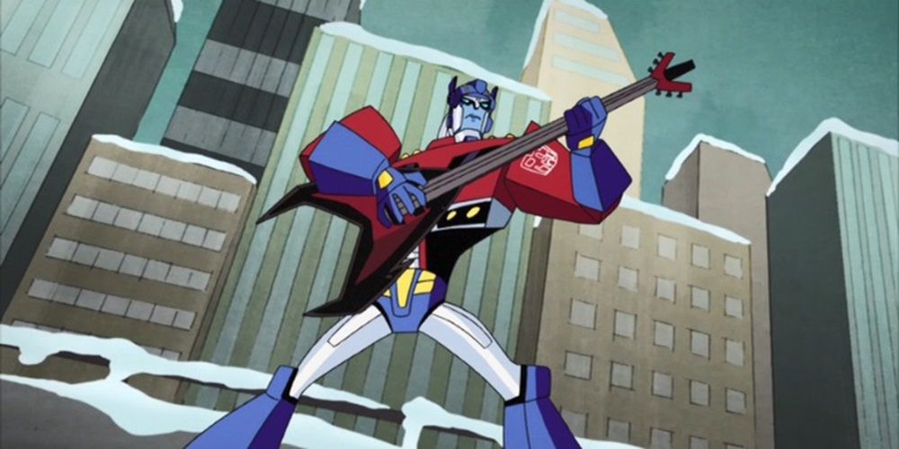 Optimus Prime segurando Laserbeak em sua forma de guitarra elétrica em Transformers Animated.