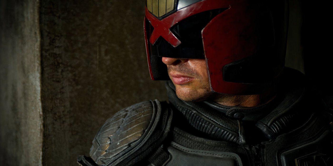 Judge Dredd (Karl Urban) is peeking around the corner of a wall in Dredd (2012).