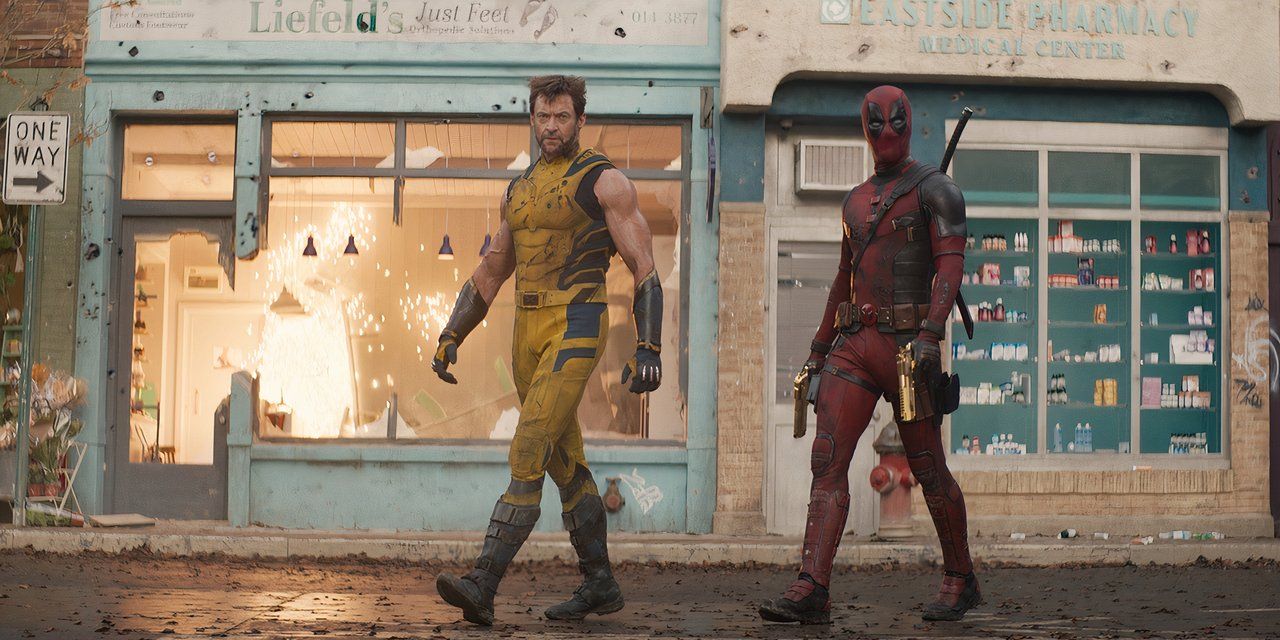 Wolverine and Deadpool are walking in front of a fiery storefront