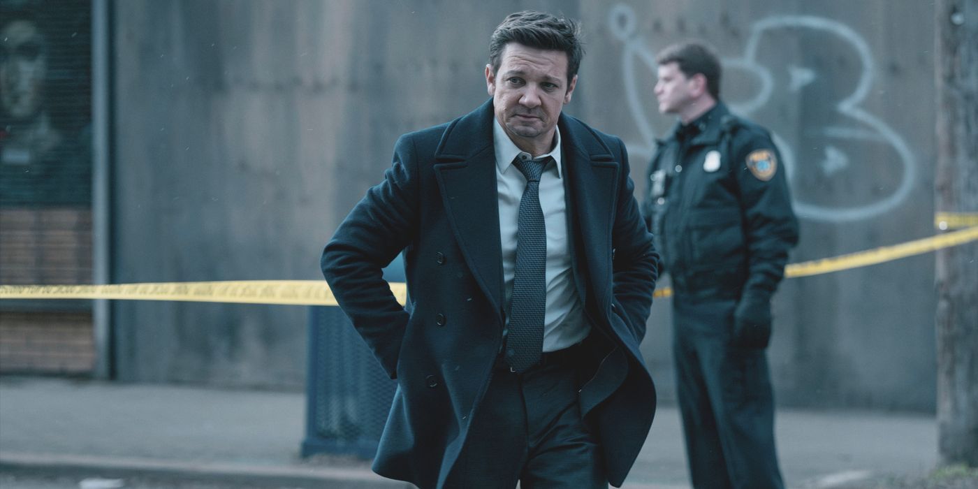 Mike McLusky (actor Jeremy Renner) wears a suit at crime scene with cops behind in Mayor of Kingstown.