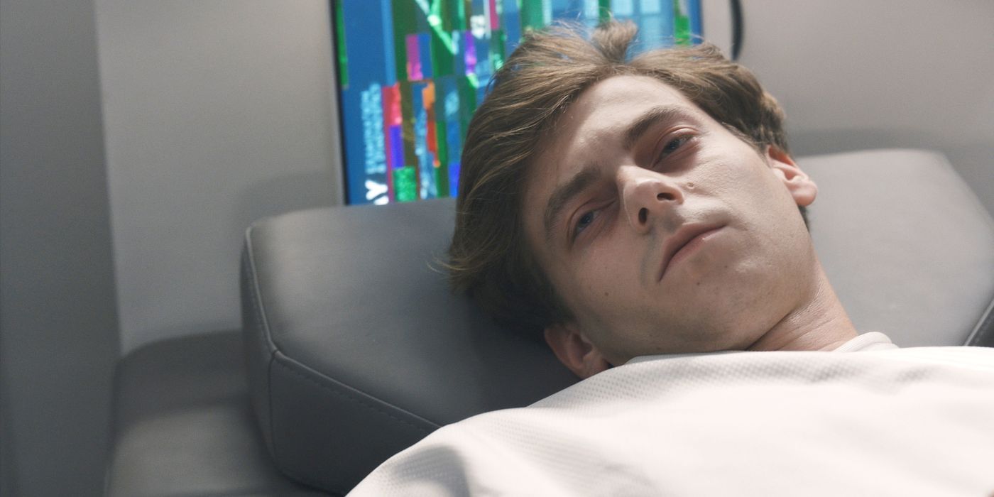 Angus (el actor Ryan Adams) acostado en una cama de hospital con una camisa blanca en The Ark, temporada 2, episodio 1