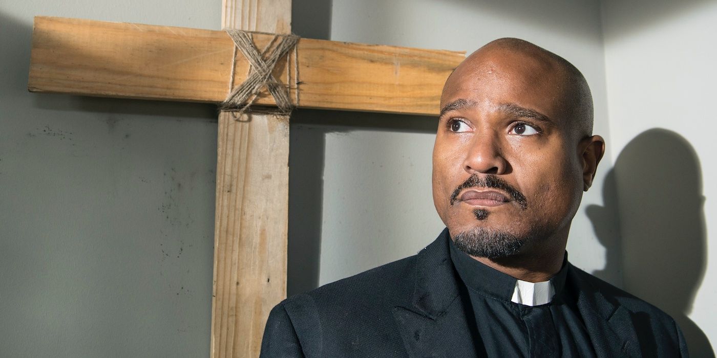 Gabriel Stokes in front of a cross on The Walking Dead