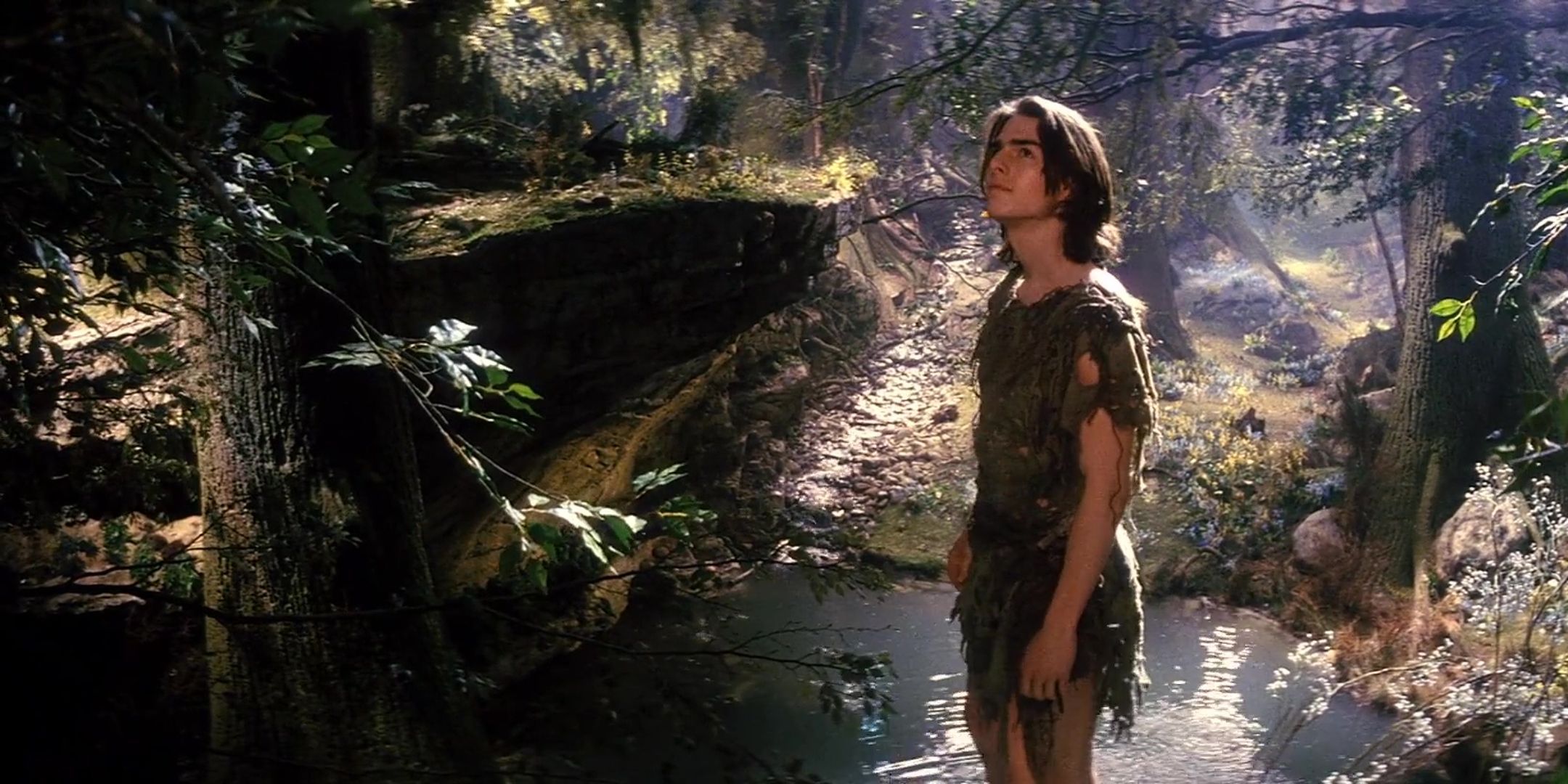 Tom Cruise as Jack in the Green poses at a pond in a forest in Legend.