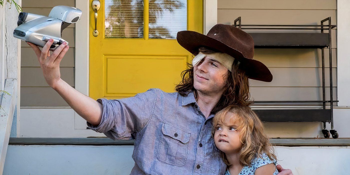 Carl wearing Rick's hat and taking a selfie with Judith on The Walking Dead.