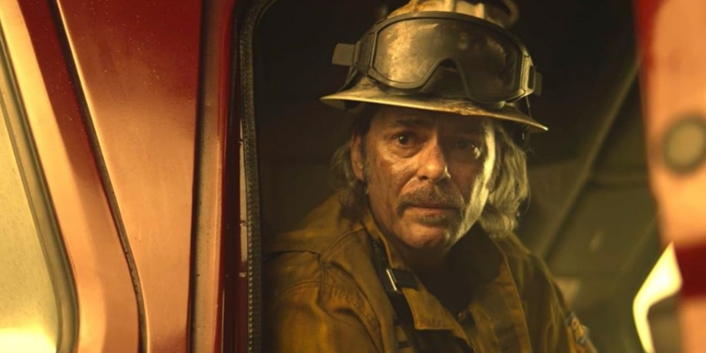 Billy Burke as Vince Leone looks out the window of a fire truck while covered in dust on Fire Country