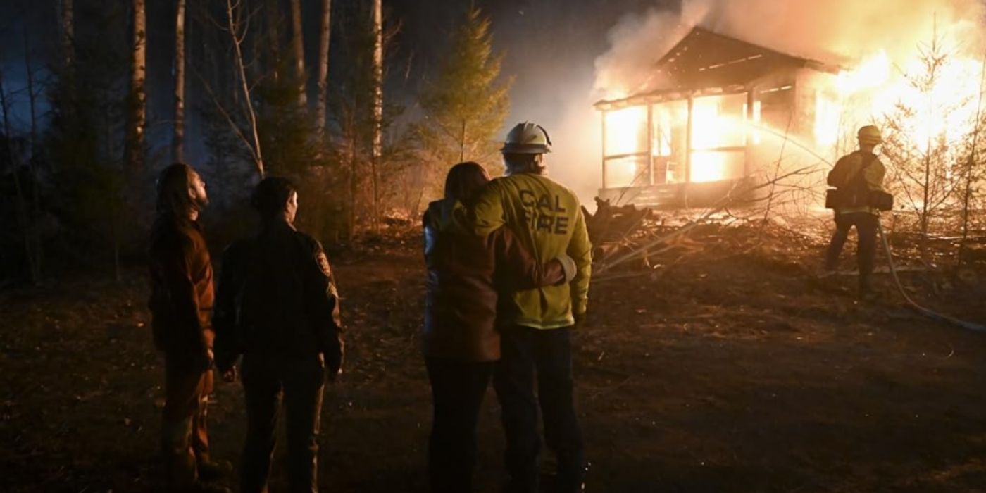 Max Thieriot as Bode Leone, Morena Baccarin as Mickey Fox, Diane Farr as Sharon Leone, and Billy Burke as Vince Leone face away from the camera and watch a cabin burn on Fire Country