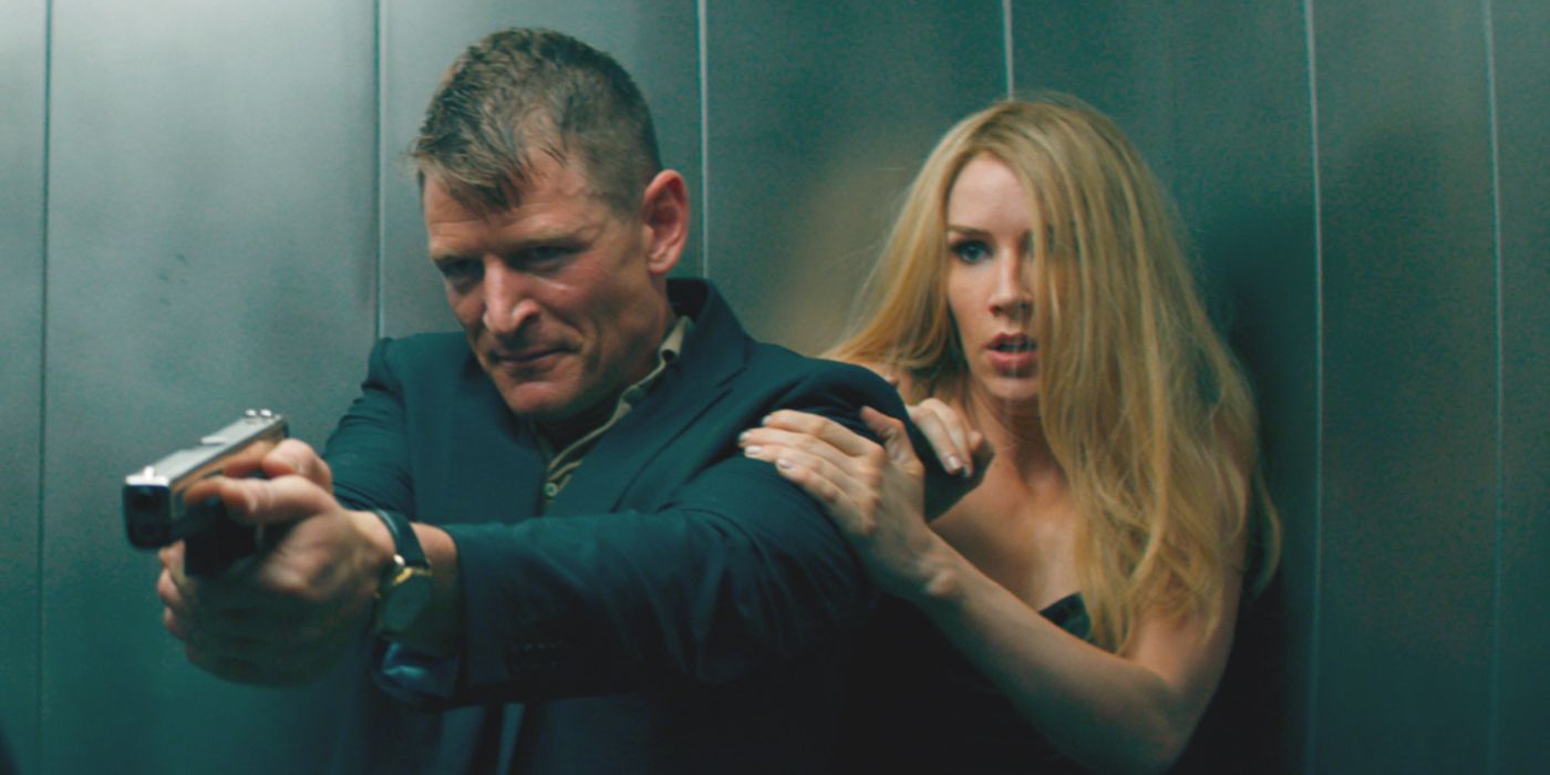 Rob (actor Philip Winchester) protects Duchess (Charlotte Kirk) in an elevator in the movie Duchess