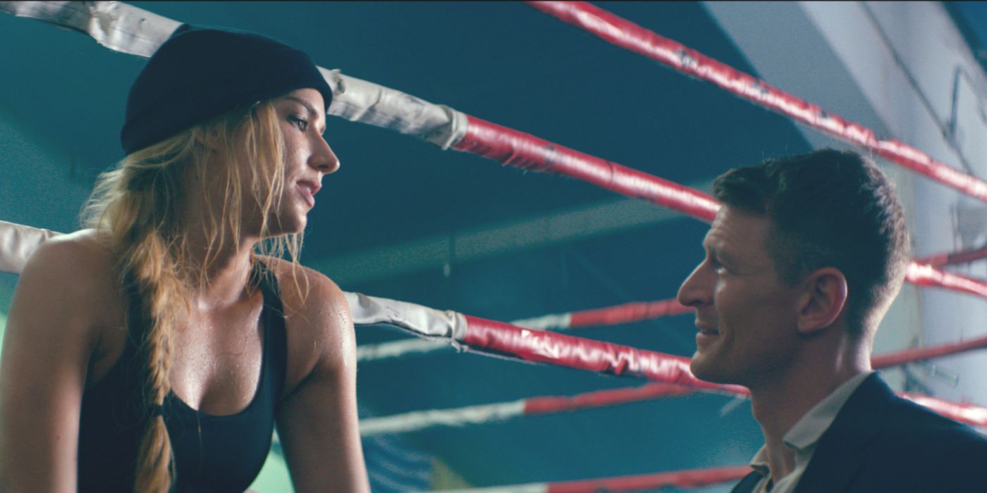 Scarlett (Charlotte Kirk) sits in a boxing ring and talks to Rob (Philip Winchester) in the movie Duchess