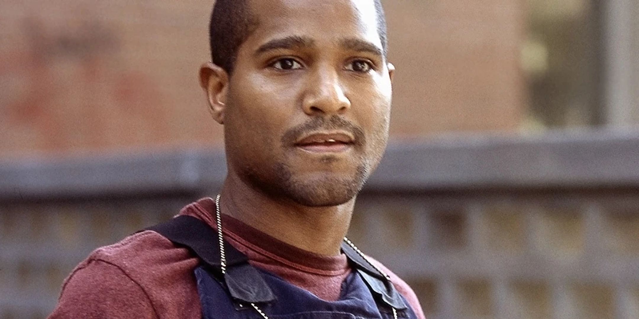 Ellis Carver de The Wire, interpretado por Seth Gilliam, vestido con una camisa roja y un chaleco policial.