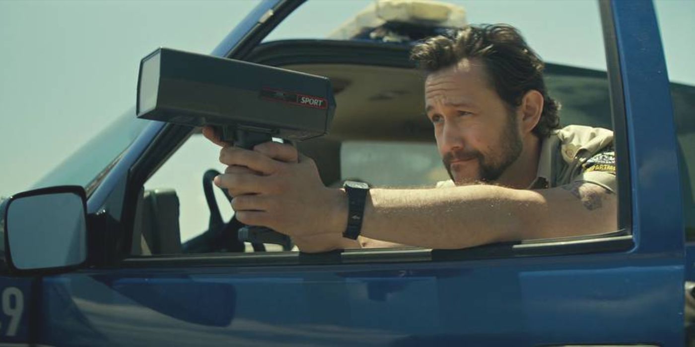 Terry (actor Joseph-Gordon Levitt) in his truck pointing a radar gun out the window in Greedy People