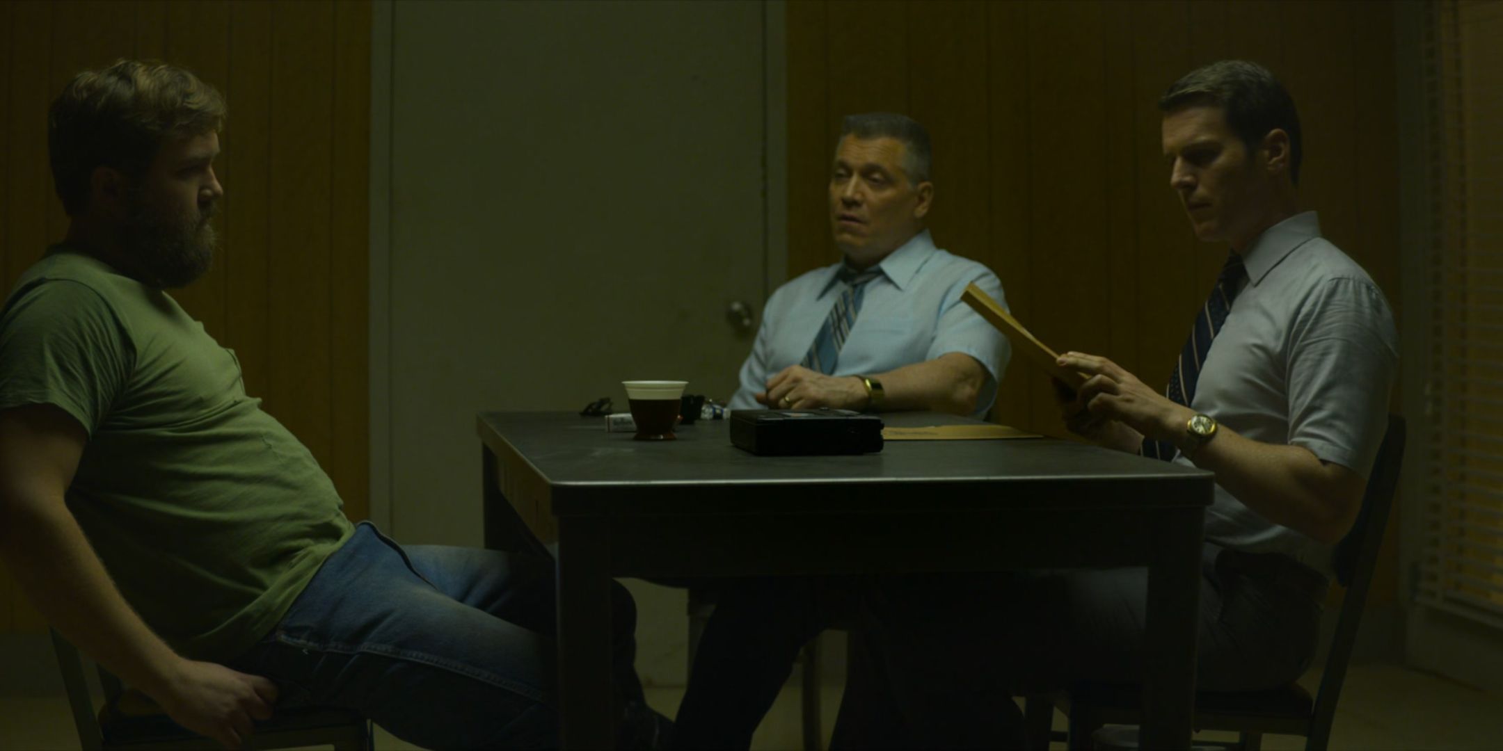 Holt McCallany as Bill Tench and Jonathan Groff as Holden Ford interview a bearded man at a table in Mindhunter