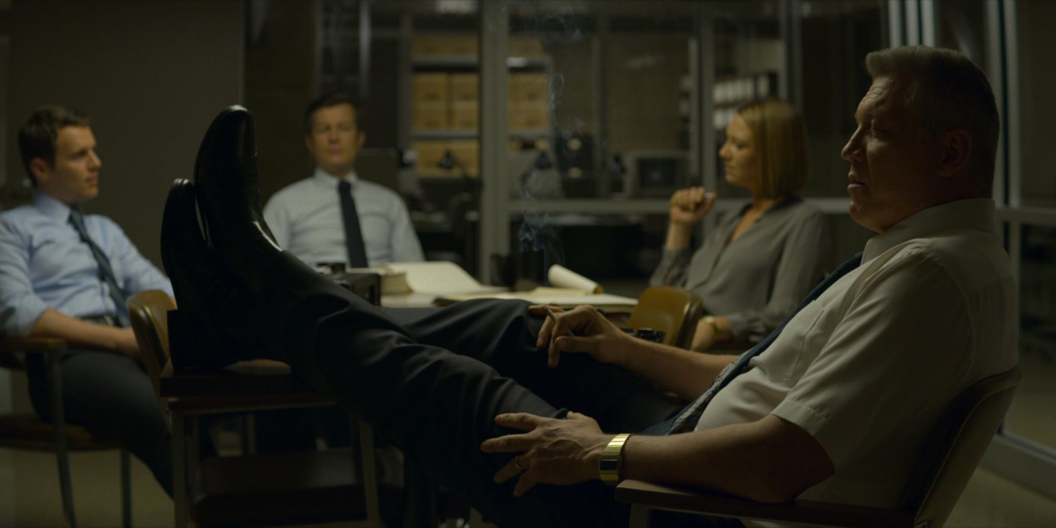 Holt McCallany as Bill Tench puts his feet up in the Quantico office with Anna Torv as Wendy Carr, Joe Tuttle as Gregg Smith and Jonathan Groff as Holden Ford in Mindhunter