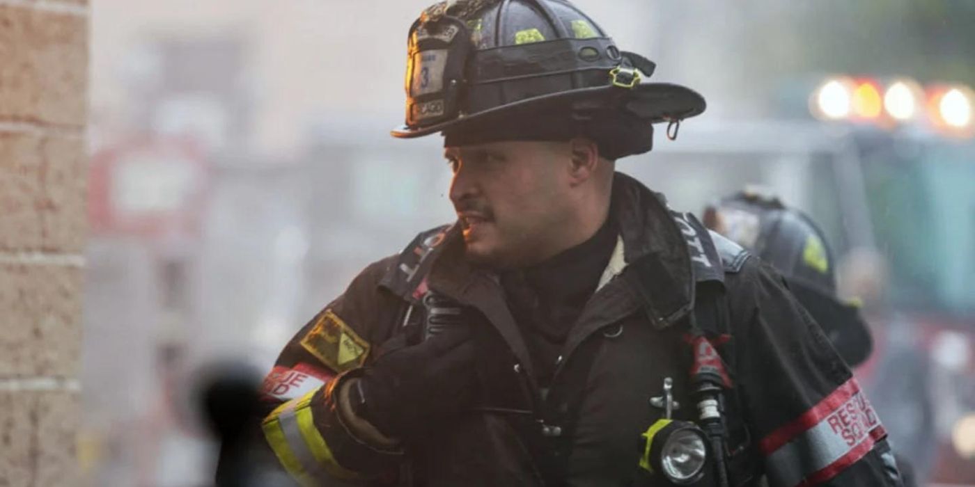 Joe Miñoso as Joe Cruz speaks into a radio while wearing his firefighter gear on Chicago Fire