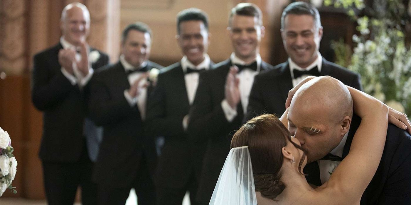 Kristen Gutoskie as Chloe Cruz and Joe Miñoso as Joe Cruz kiss in front of their wedding party on Chicago Fire