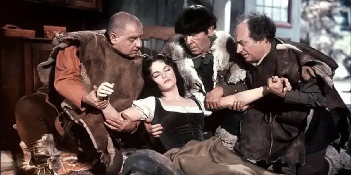 Carol Heiss as Snow White in her cursed sleep being held by the Stooges from Snow White and the Three Stooges (1961)