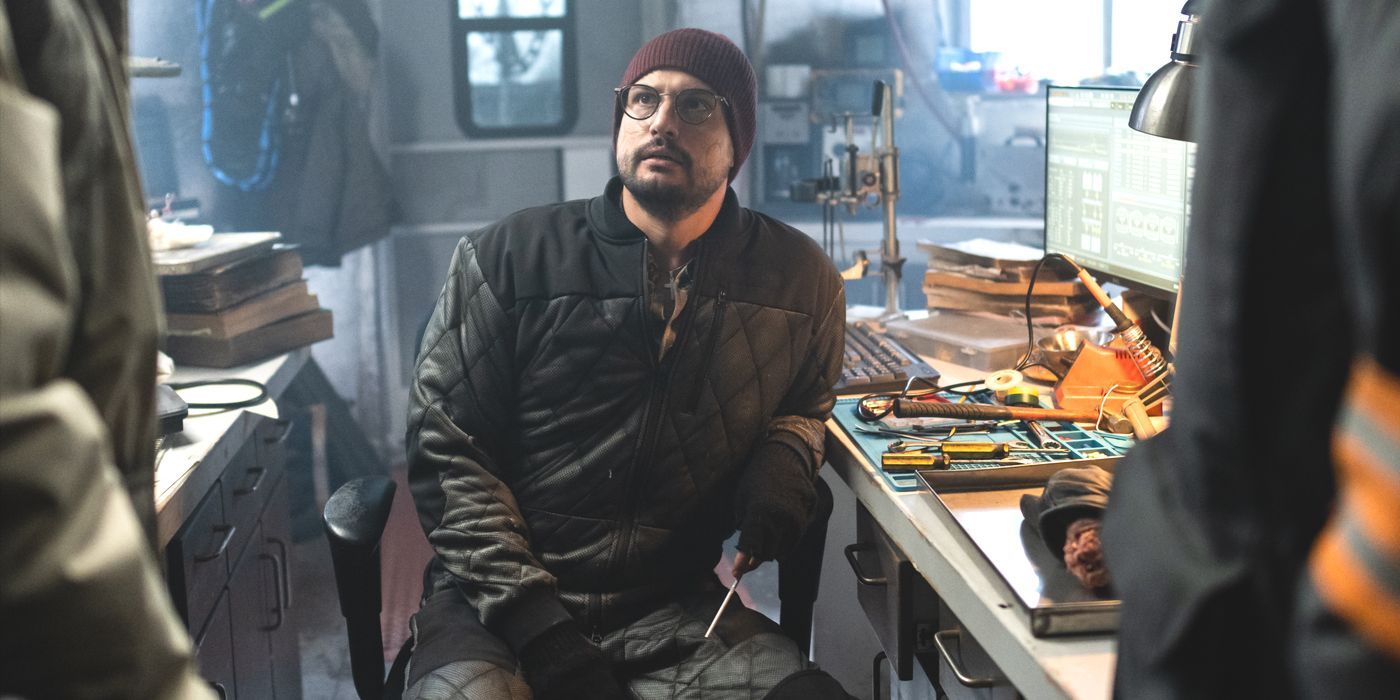 Javi (actor Roberto Urbina) sits at his lab table next to a severed hand in season 4 of Snowpiercer