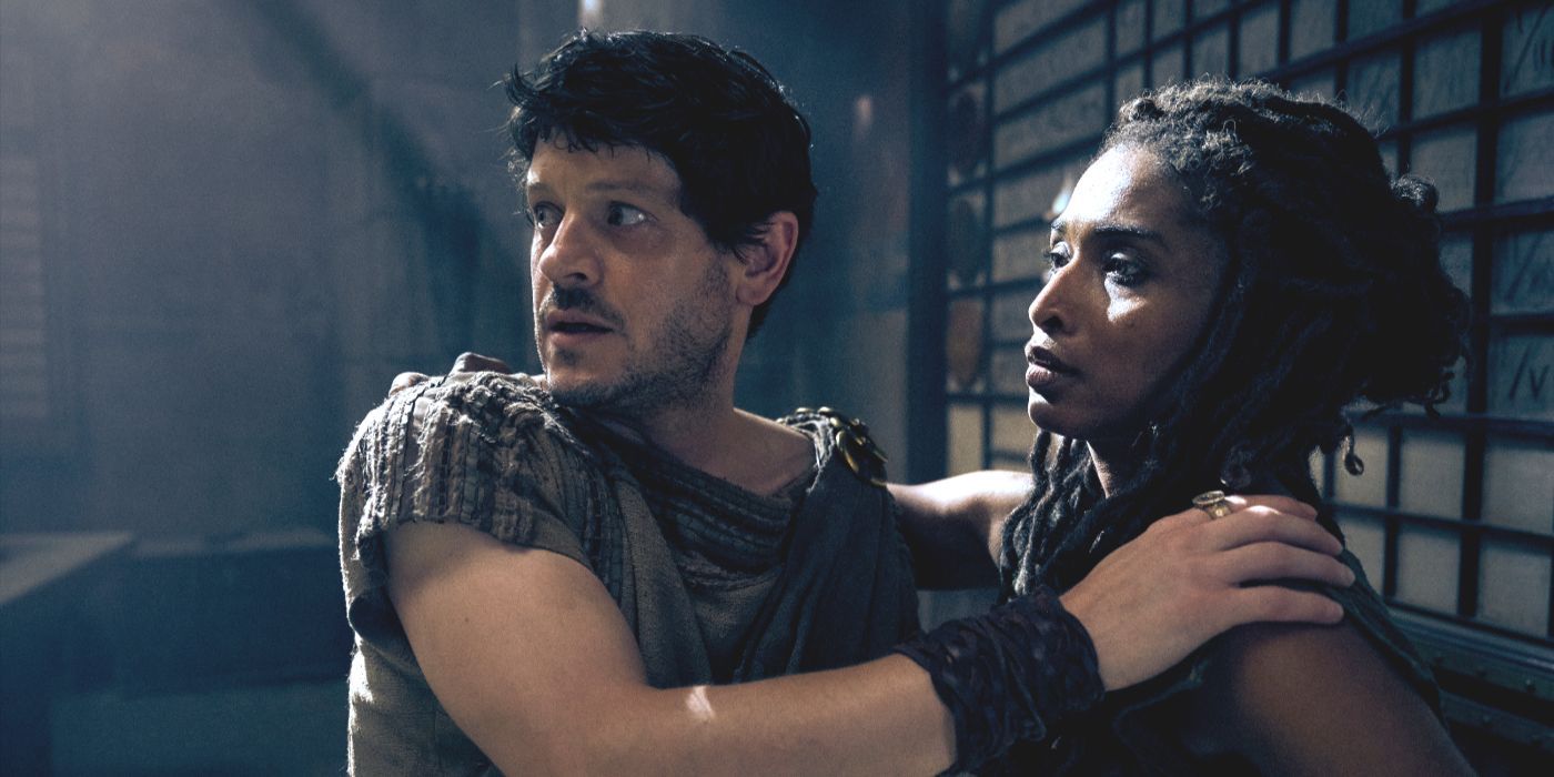 Tenax (actor Iwan Rheon) looks over his shoulder while holding Cala in “Those About to Die,” episode 7