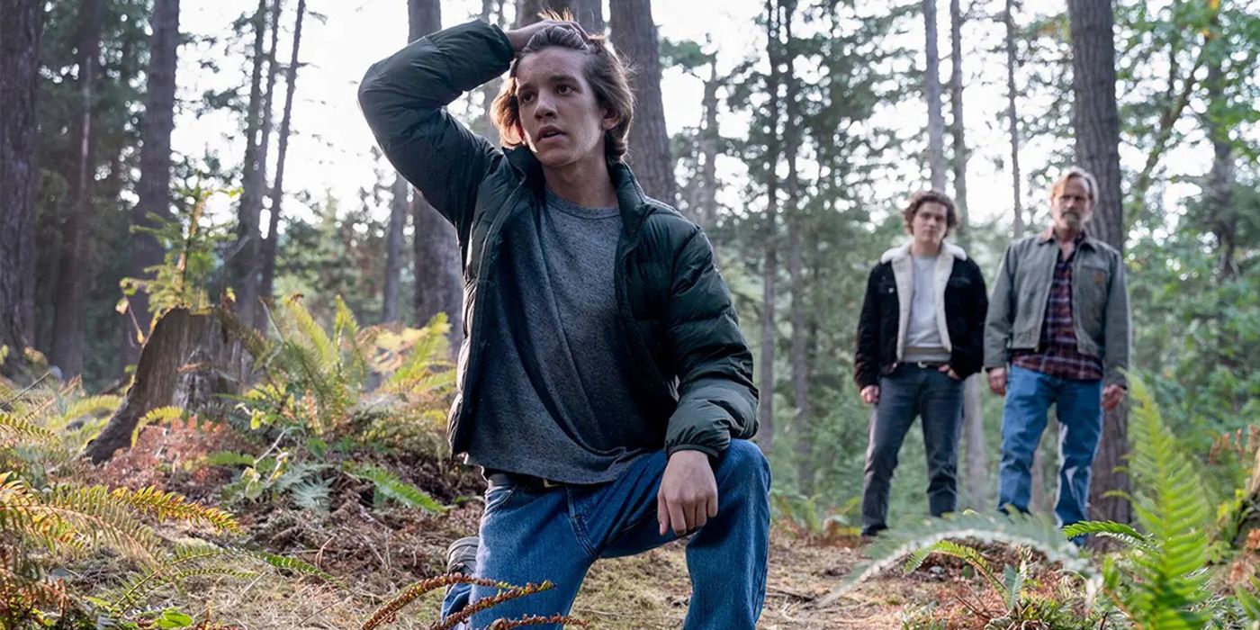 A young Colter with his hand on his head in the forest as Ashton and Russell look on in Tracker.