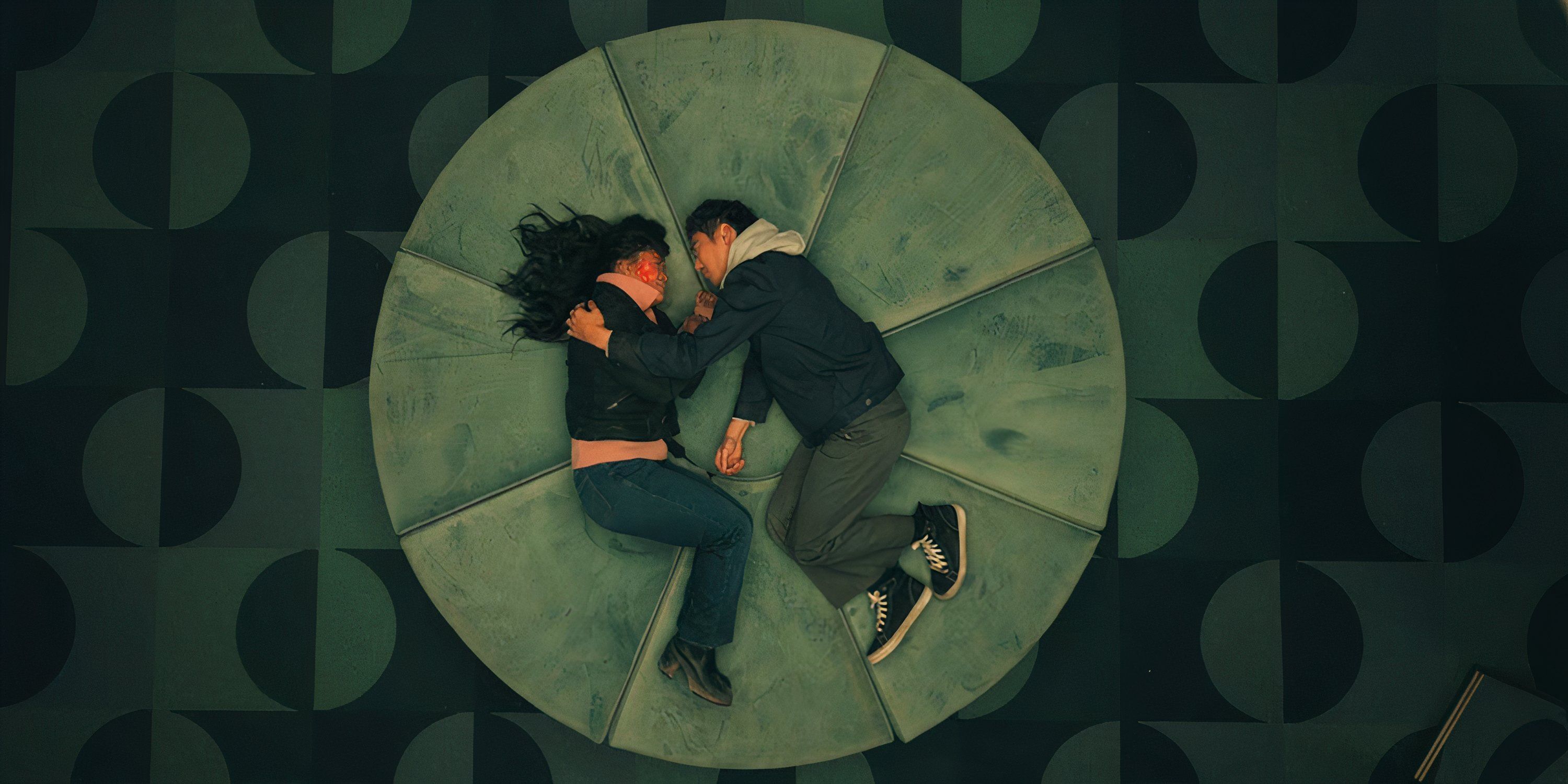 Ben and Jennifer lie on a large, round cube. Ben comforts Jennifer as her face glows from Durango particles in The Umbrella Academy season 4. Shion in The Umbrella Academy season 4.