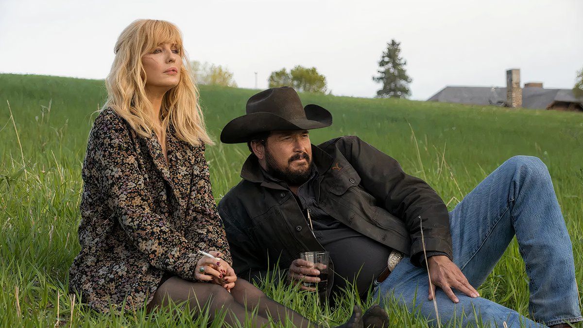 Beth and Rip taking in a sunset on the grass of the ranch in Yellowstone.