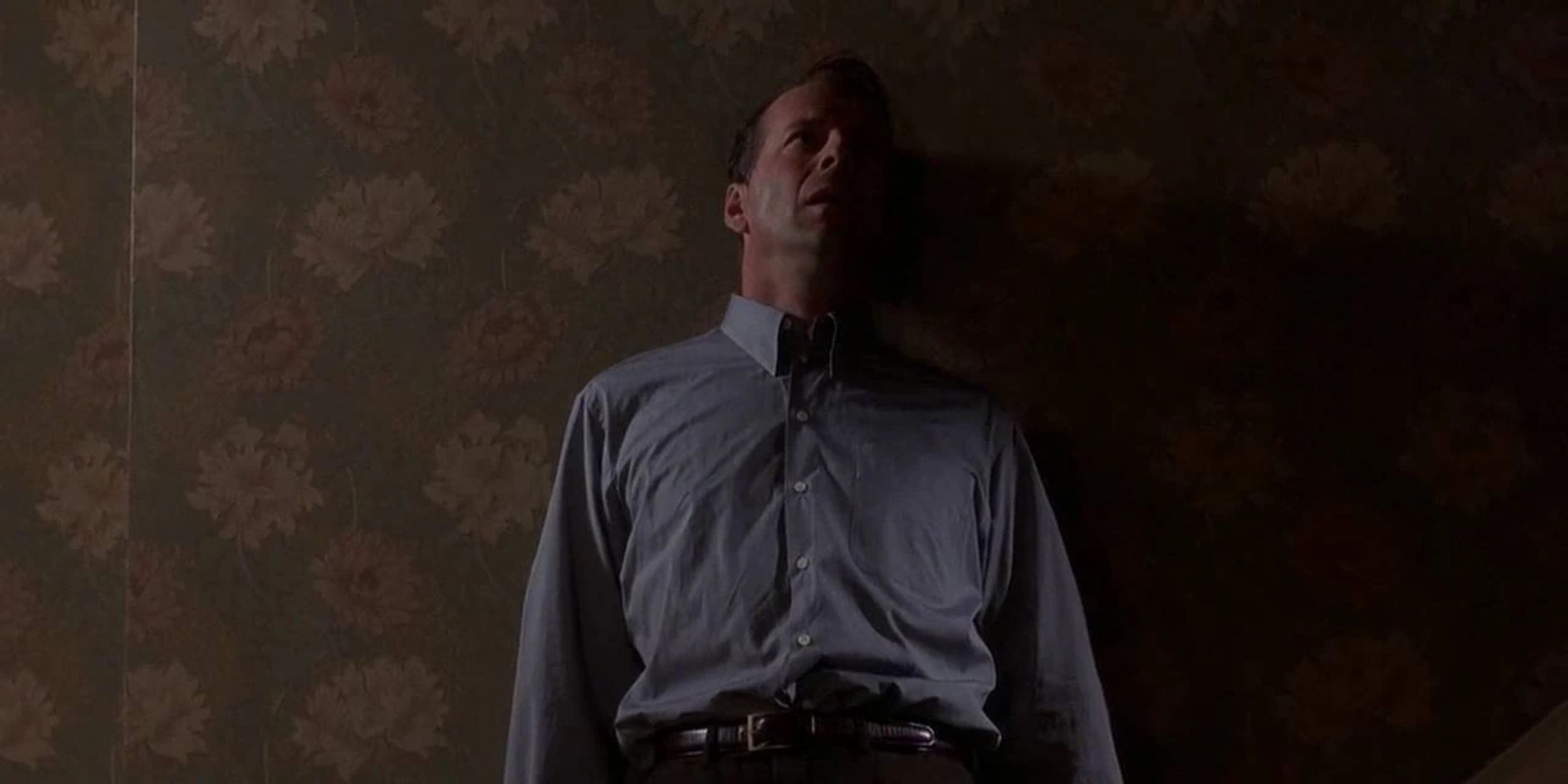 Bruce Willis como Malcolm tirado en la pared en El sexto sentido.