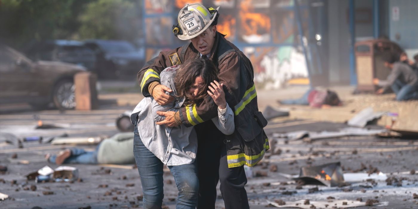 Chief Pascal, played by Dermot Mulroney, escorts a woman from a fire scene in Chicago Fire Season 13