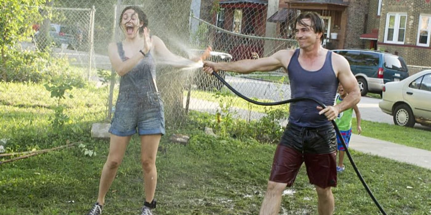 Emmy Rossum as Fiona Gallagher screams while Dermot Mulroney as Sean Pierce sprays her with a hose on Shameless