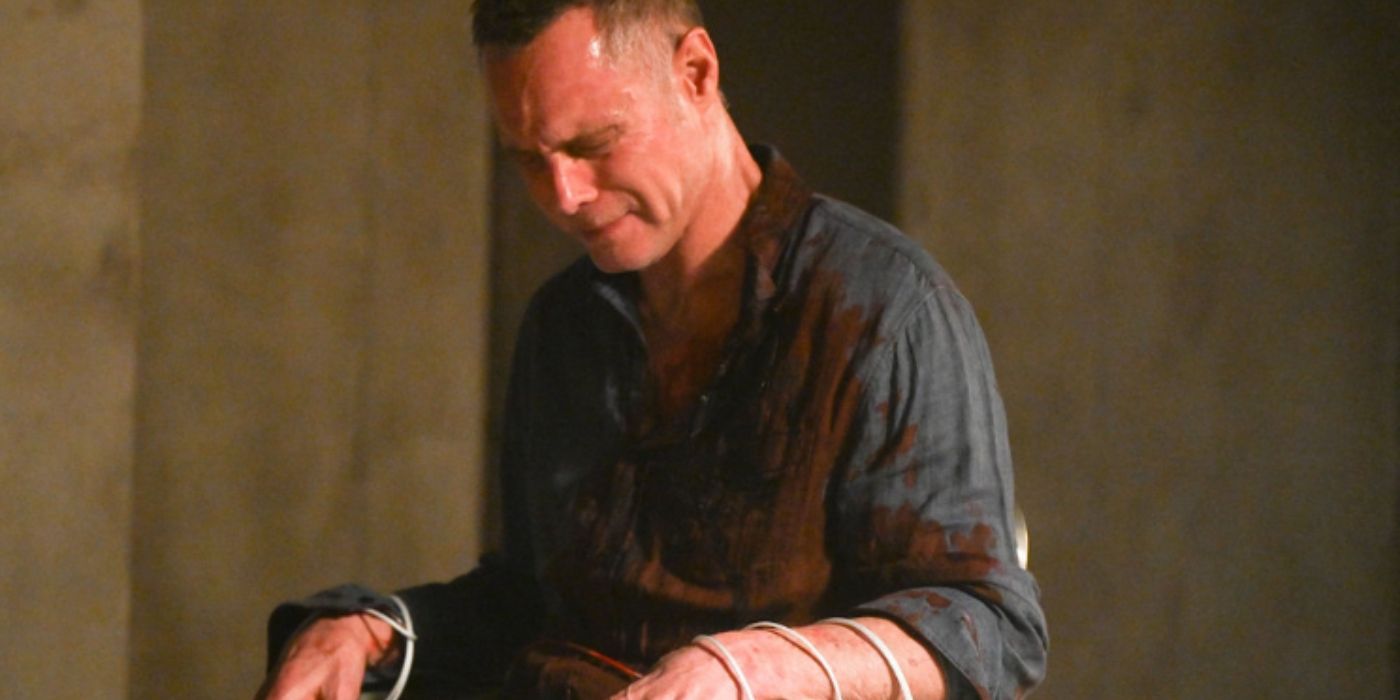 Jason Beghe as Hank Voight weeps in pain while tied to a chair and covered in blood on Chicago PD