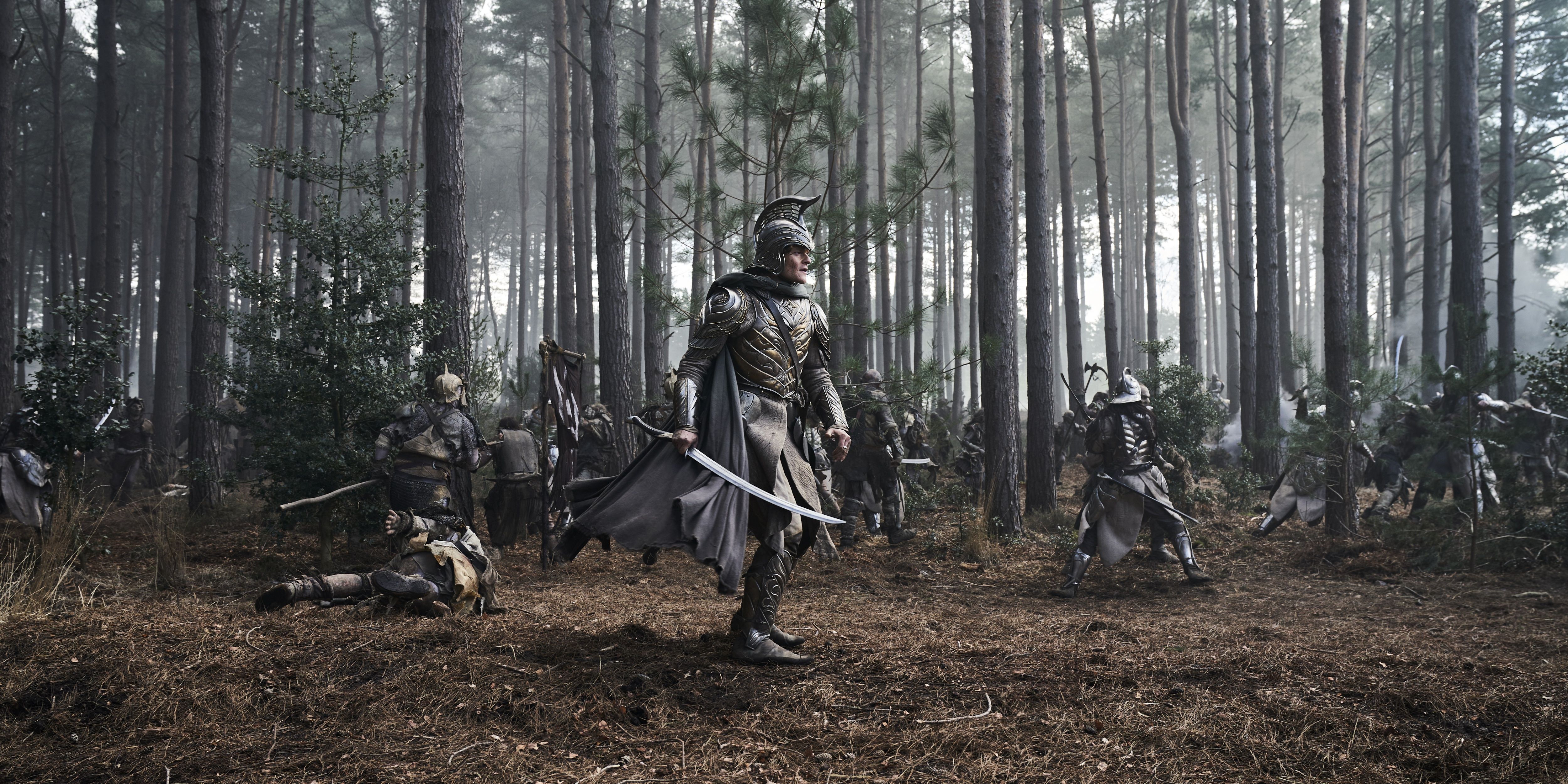 An armored Elrond stands in the middle of a forest battle in The Rings of Power Season 2