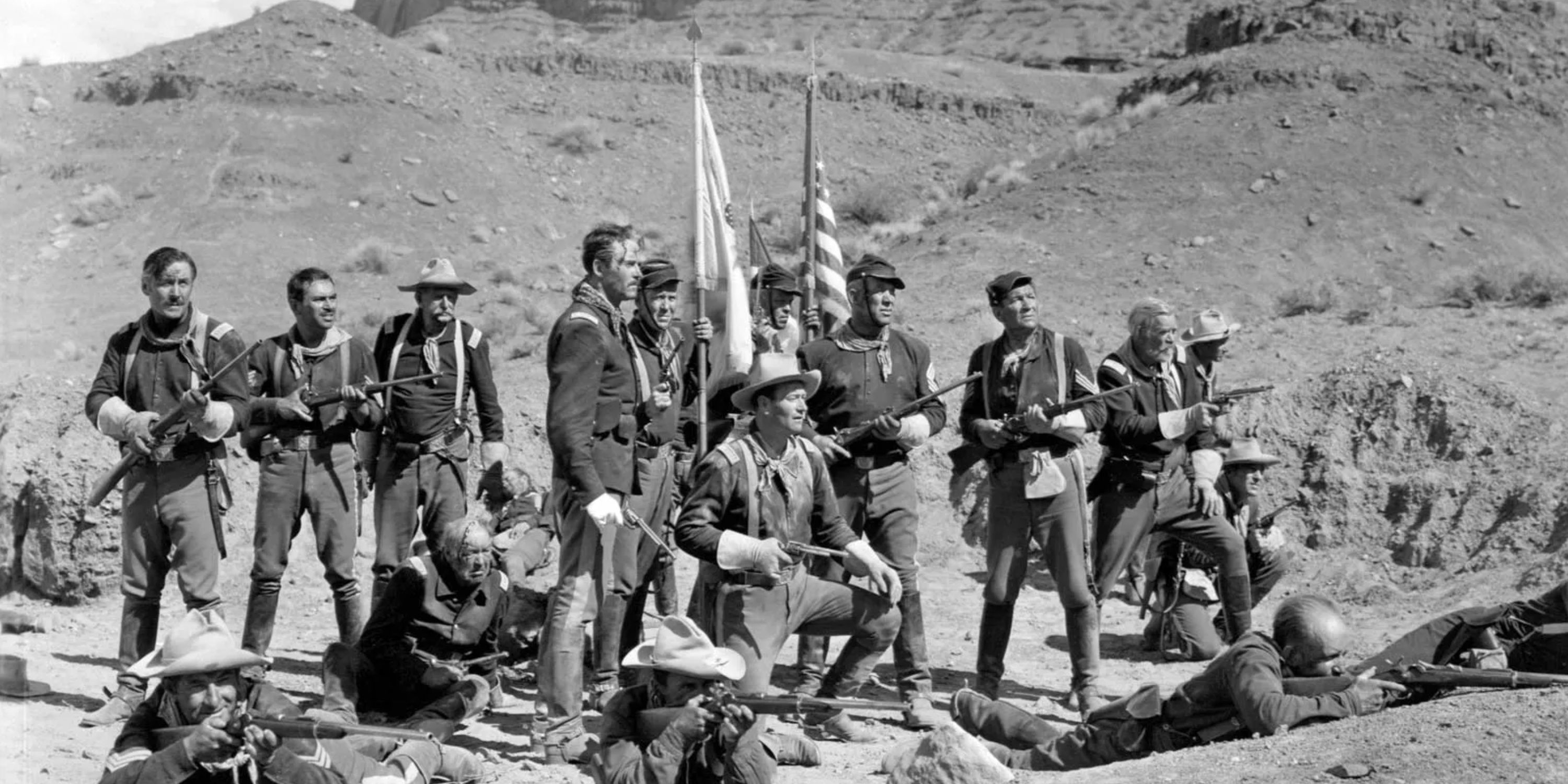 A group of soldiers aim their firearms in the desert in the film Fort Apache.