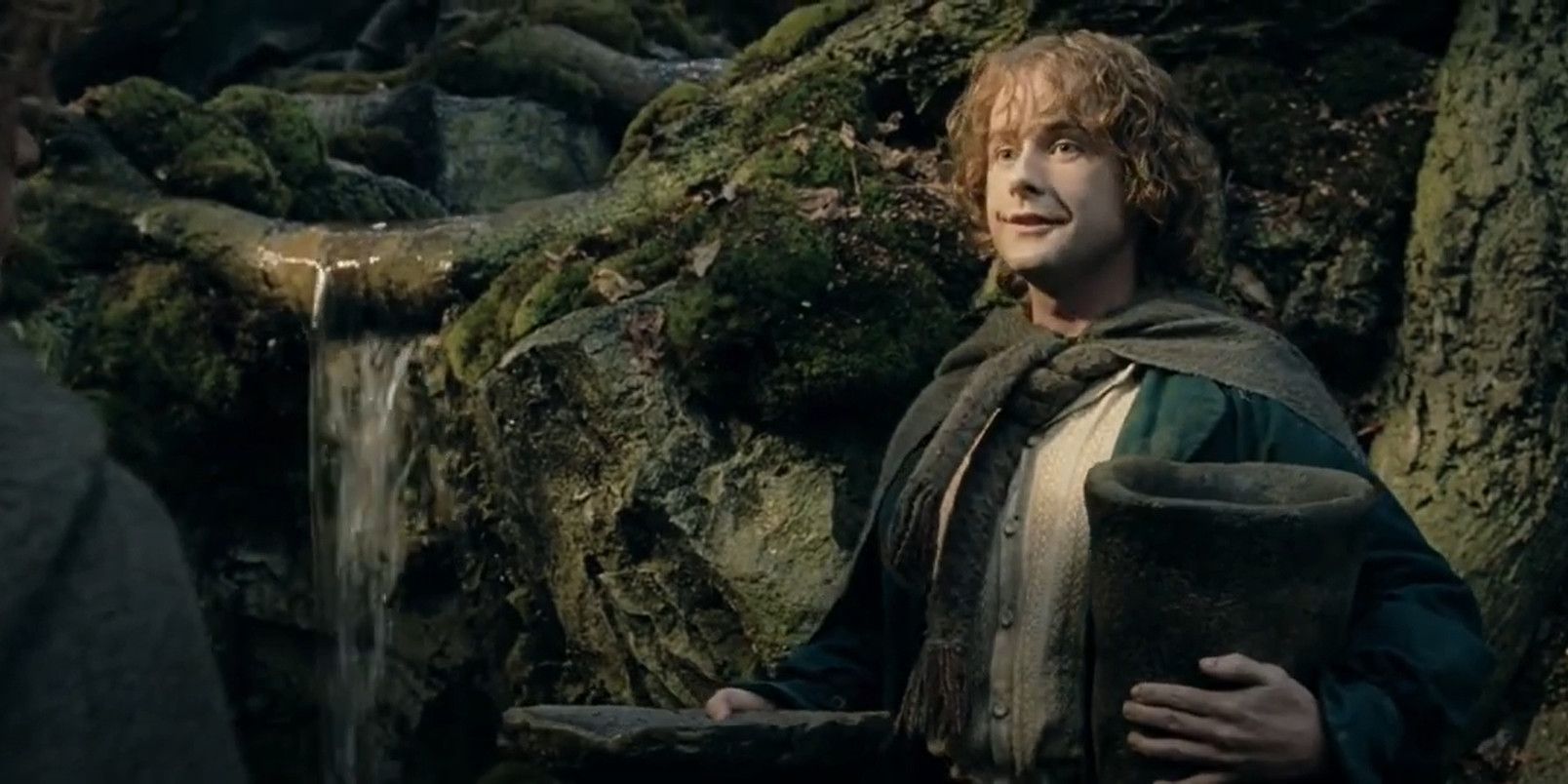 Pippin smiling while holding Ent-draught in The Lord of the Rings: The Two Towers