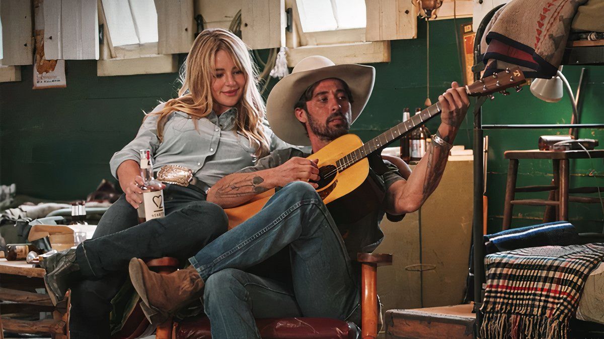 Laramie sits with Walker while he plays a tune on his guitar in Yellowstone.