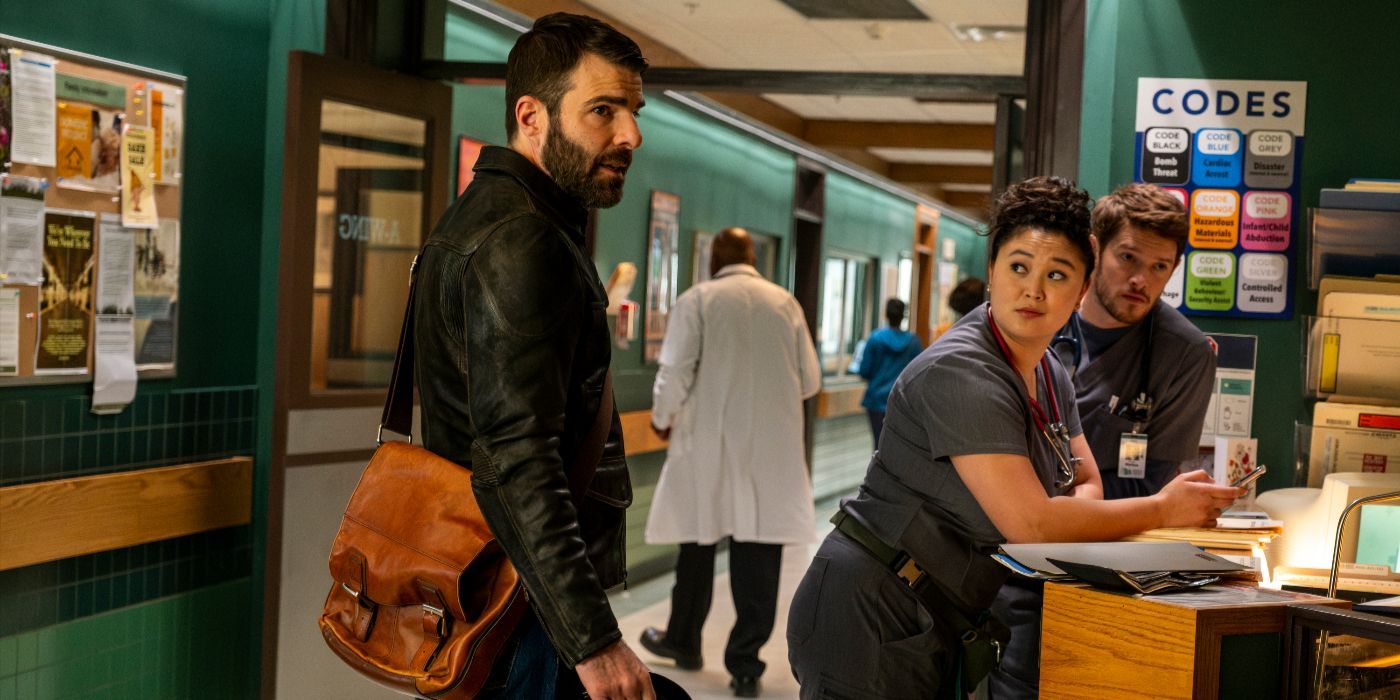 Dr. Oliver Wolf (actor Zachary Quinto) stands in the hospital hallway next to Brilliant Minds interns