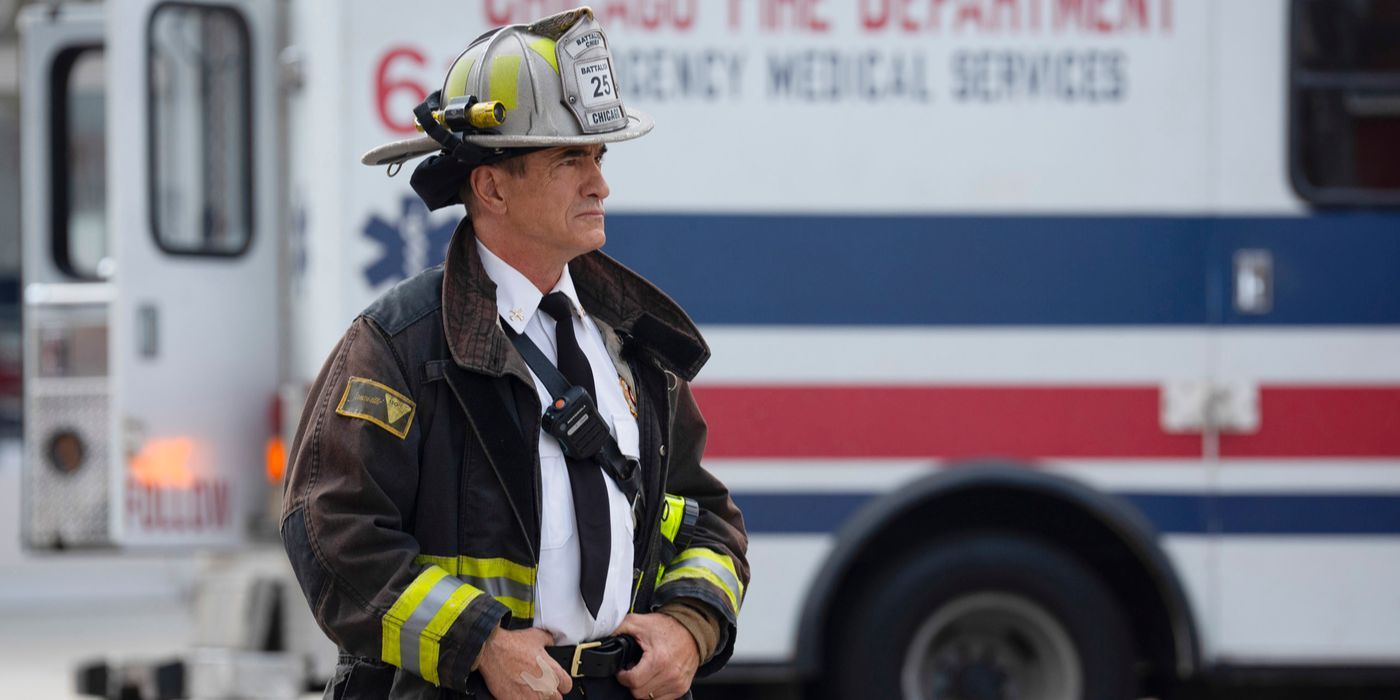 Pascal, played by Dermot Mulroney, in firefighter gear with an ambulance behind him on Chicago Fire