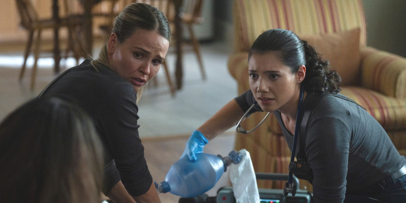 Paramedics Violet and Novak kneel on either side of a patient, looking into camera, on Chicago Fire