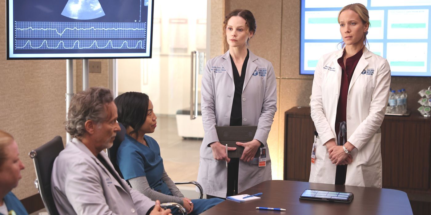 Lenox and Asher (Sarah Ramos and Jessy Schram) stand in front of a hospital meeting on Chicago Med