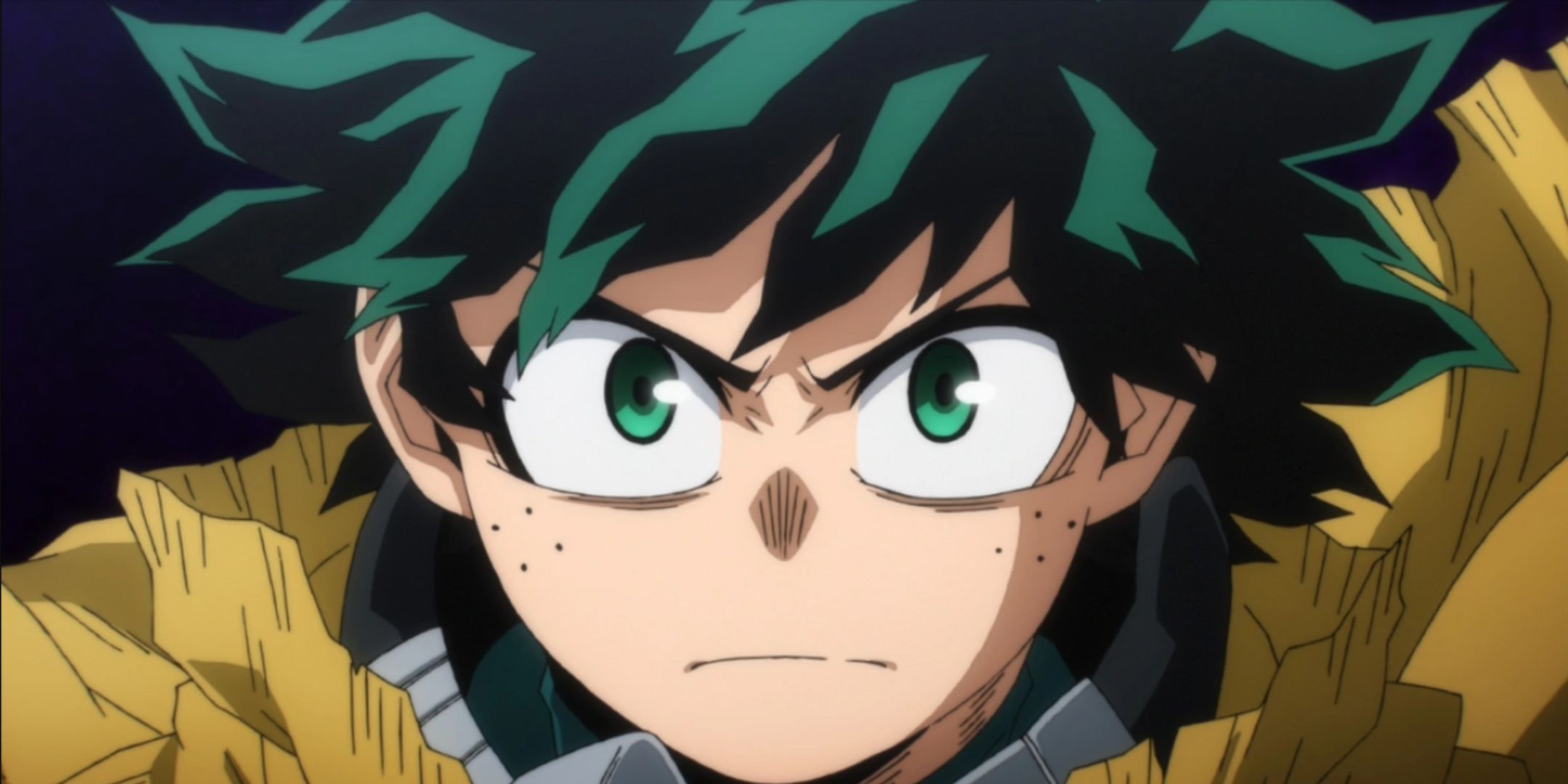 Deku looks forward with resolve while wearing a yellow coat in the My Hero Academia anime.