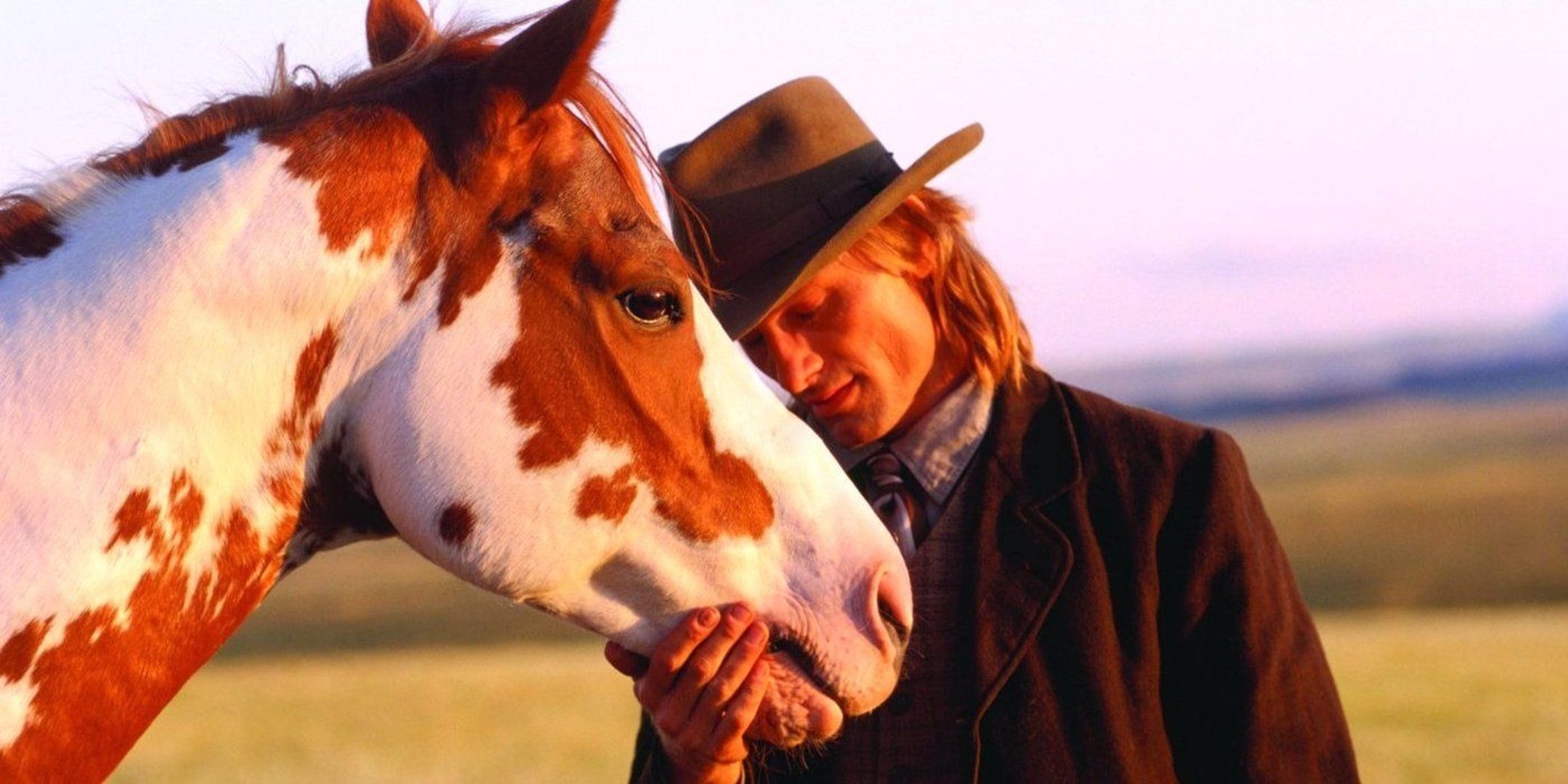 A Frank Hopkins rubs his head on his horse, Hidalgo.