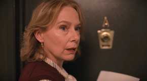 Jan Bellows is standing outside her apartment holding a note in Only Murders in the Building Season 1.