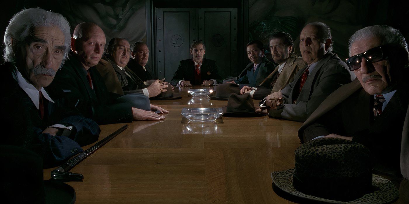 The heads of the mob families in Gotham listen as Jack/The Joker says that he is taking over the crime syndicate in Batman (1989).