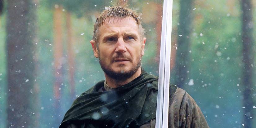 Godfrey de Ibelin (Liam Neeson) looks serious and is holding a sword in Kingdom of Heaven.
