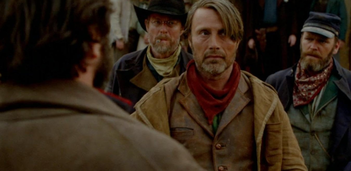 Mads Mikkelsen em Jon cercado por pessoas da fronteira em The Salvation.