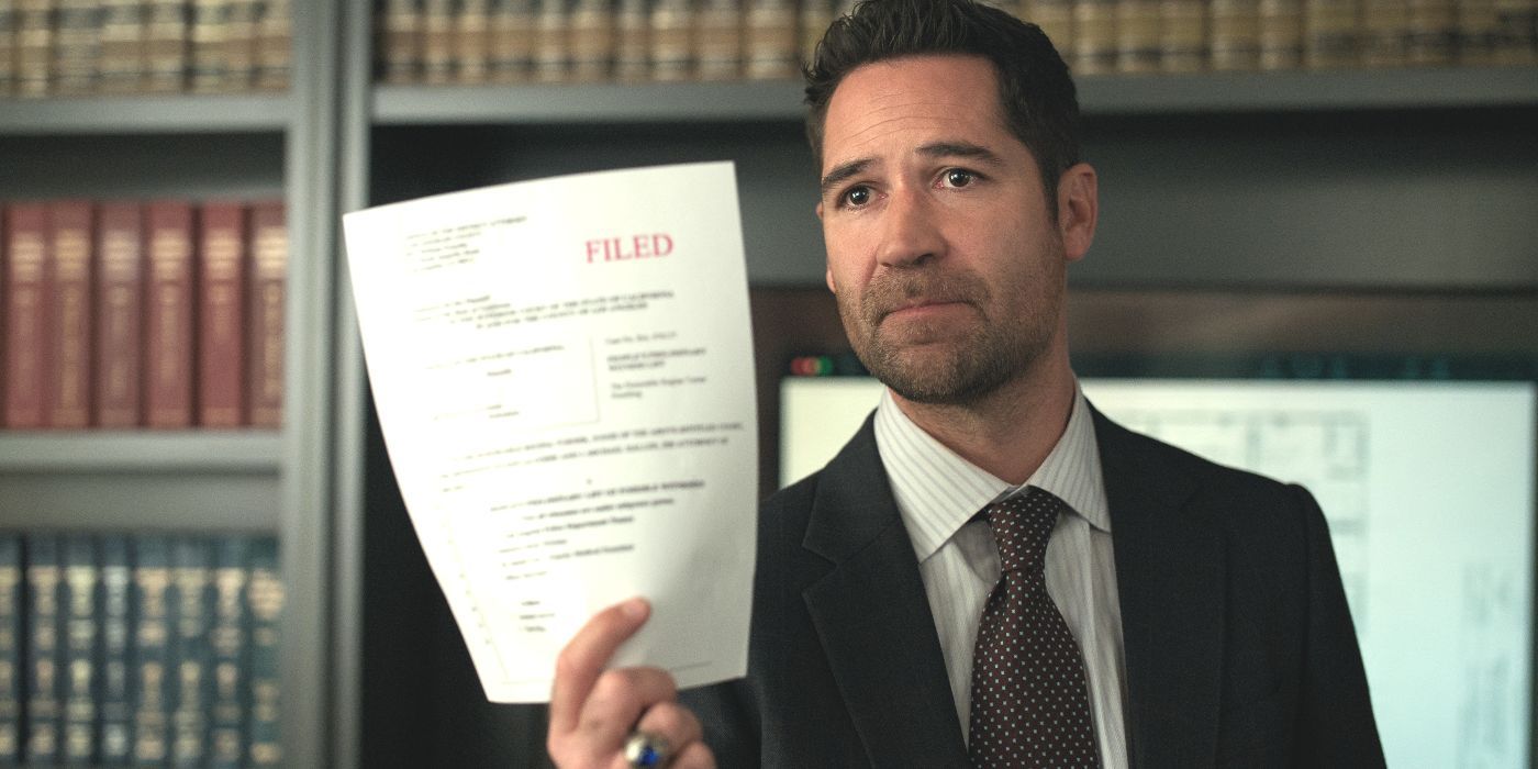 Mickey Haller wears a black suit and angrily holds up a court paper in The Lincoln Lawyer Season 3