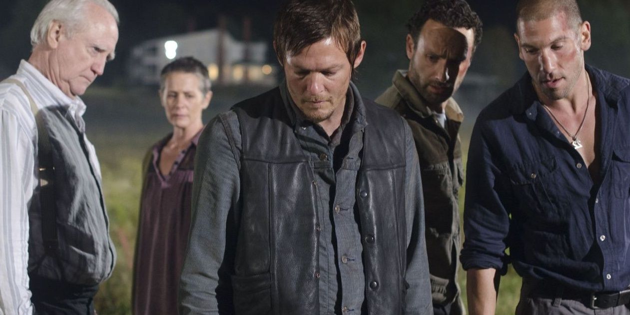 daryl, rick, shane, herschel, and carol look down at dale as he dies