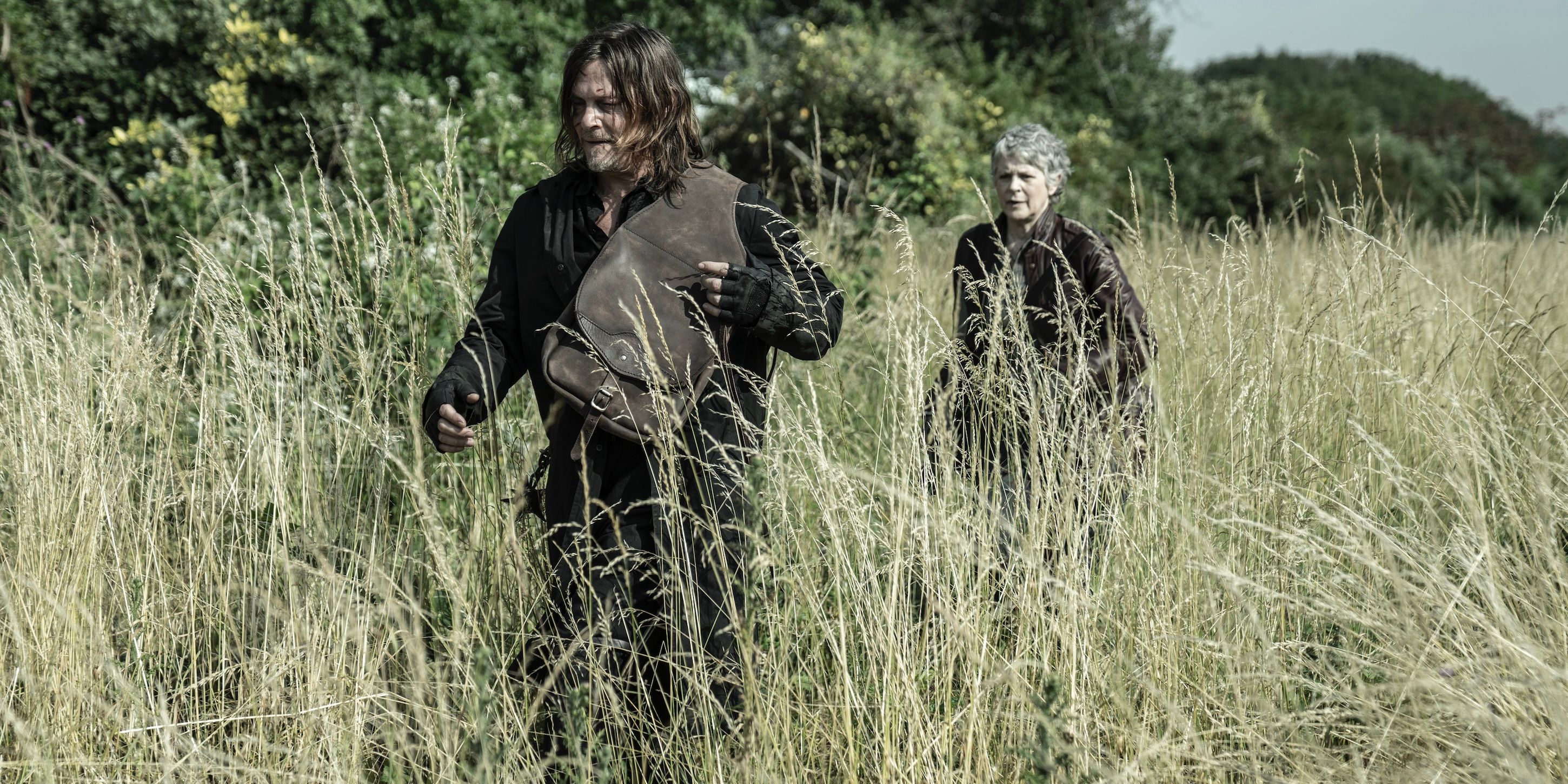 Daryl (Norman Reedus) & Carol (Melissa McBride) walking in a field on The Walking Dead: Daryl Dixon