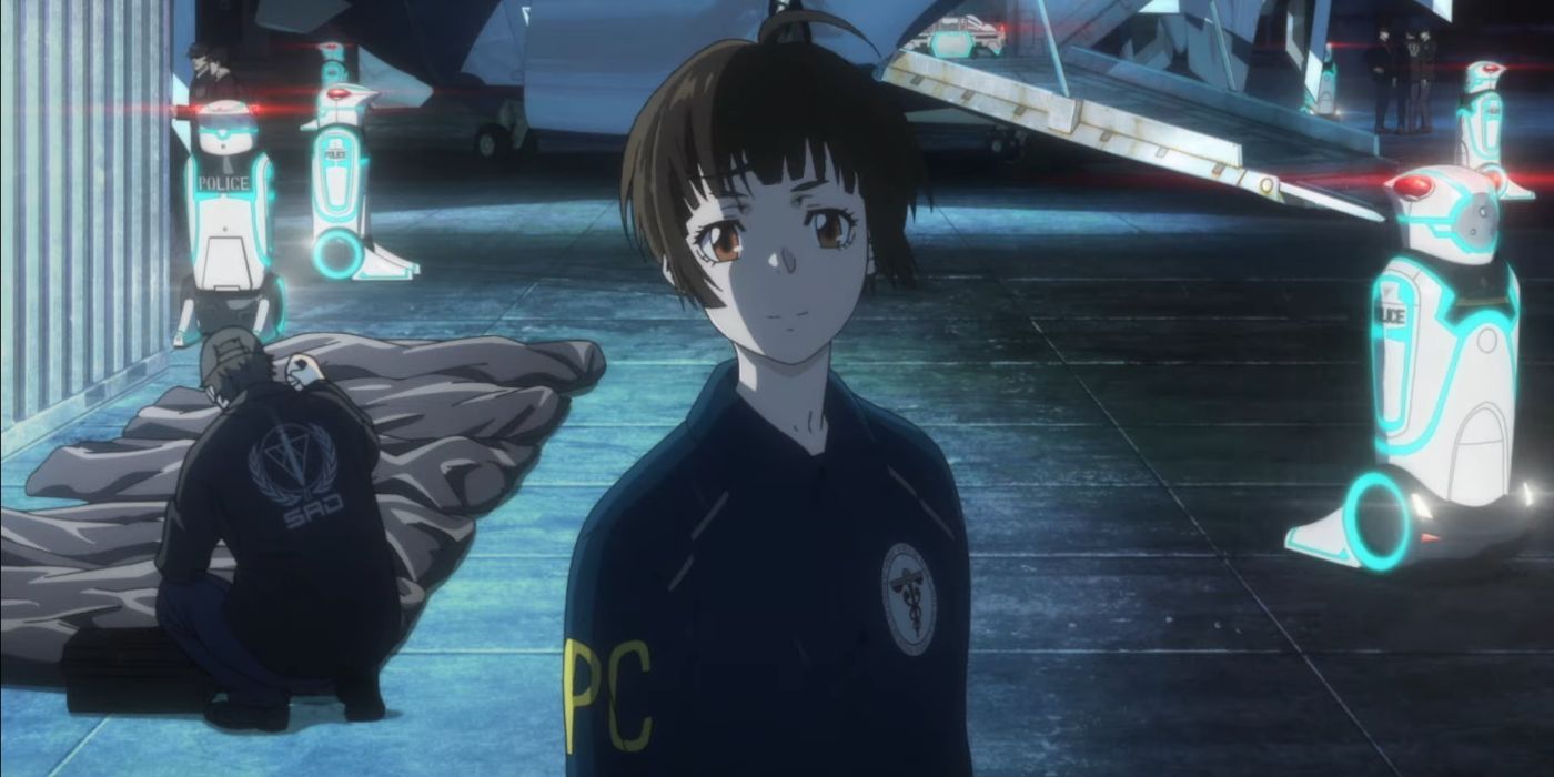 Akane Tsune smiles while SAD members investigate a scene behind her in Psycho Pass: Providence.