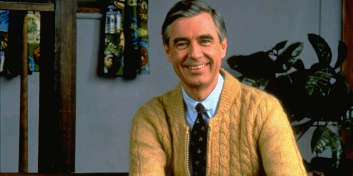 Mister Rogers usa um suéter amarelo no bairro de Mister Rogers.